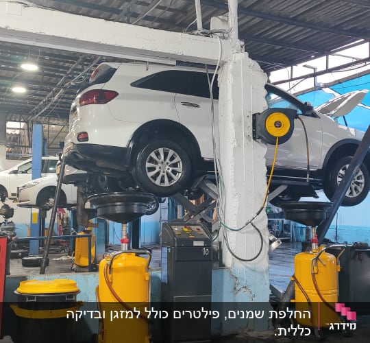 רכב על מעלית במוסך עם ציוד תחזוקה